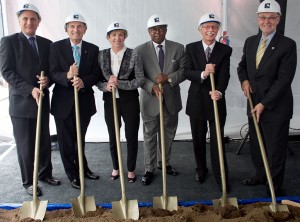 Six people with shovels and hardhats at groundbreaking