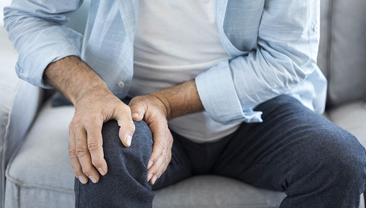 Man holding knee as if in pain