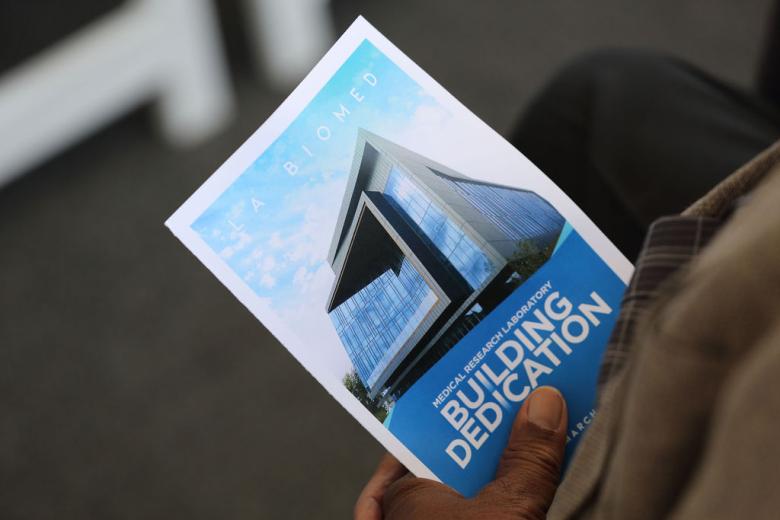 Man holding Medical Research Laboratory Building Dedication brochure