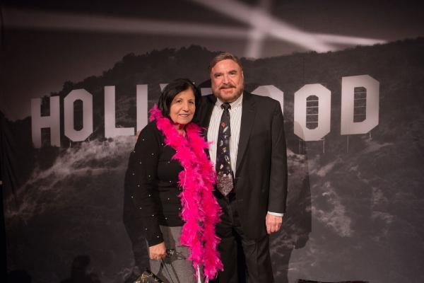 Spirit of Innovation Gala attendees in front of Hollywood sign backdrop holding a pink boa