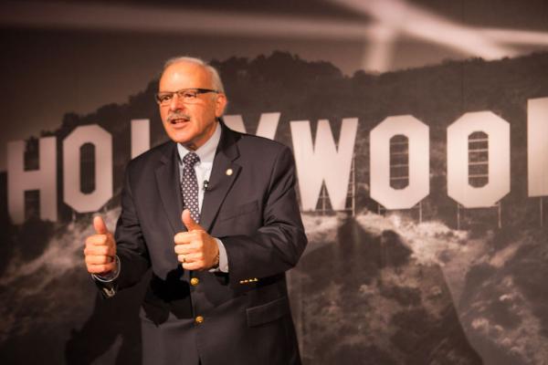 Spirit of Innovation Gala attendee giving two thumbs up in front of Hollywood sign backdrop