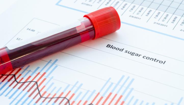 Sample blood for screening diabetic test in blood tube on blood sugar control chart.