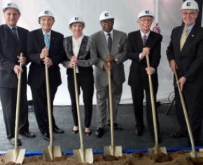Six people with shovels and hardhats at groundbreaking